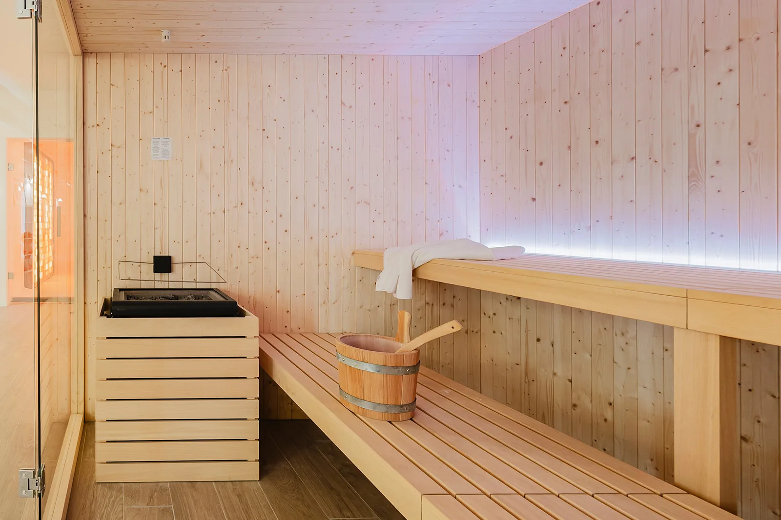 Wooden benches and sauna heater at Guild Siena